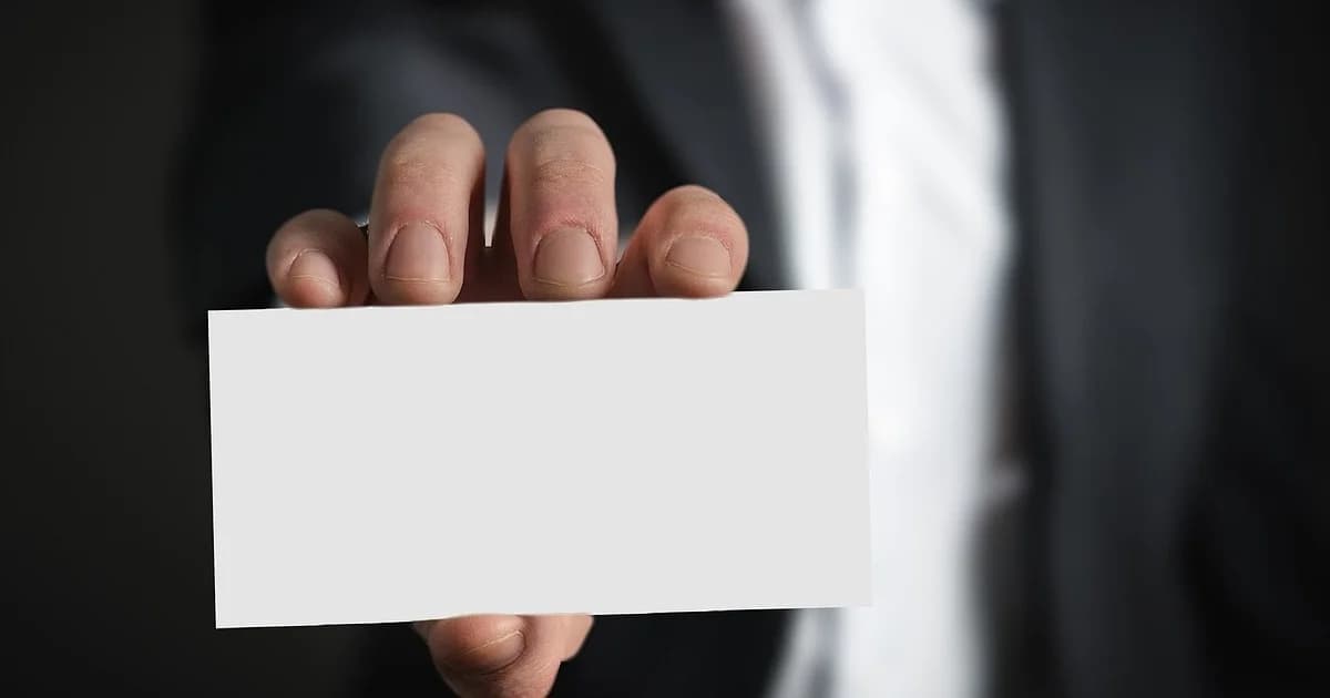 Una mano que ofrece una tarjeta de presentación en blanco, lista para tu propio nombre