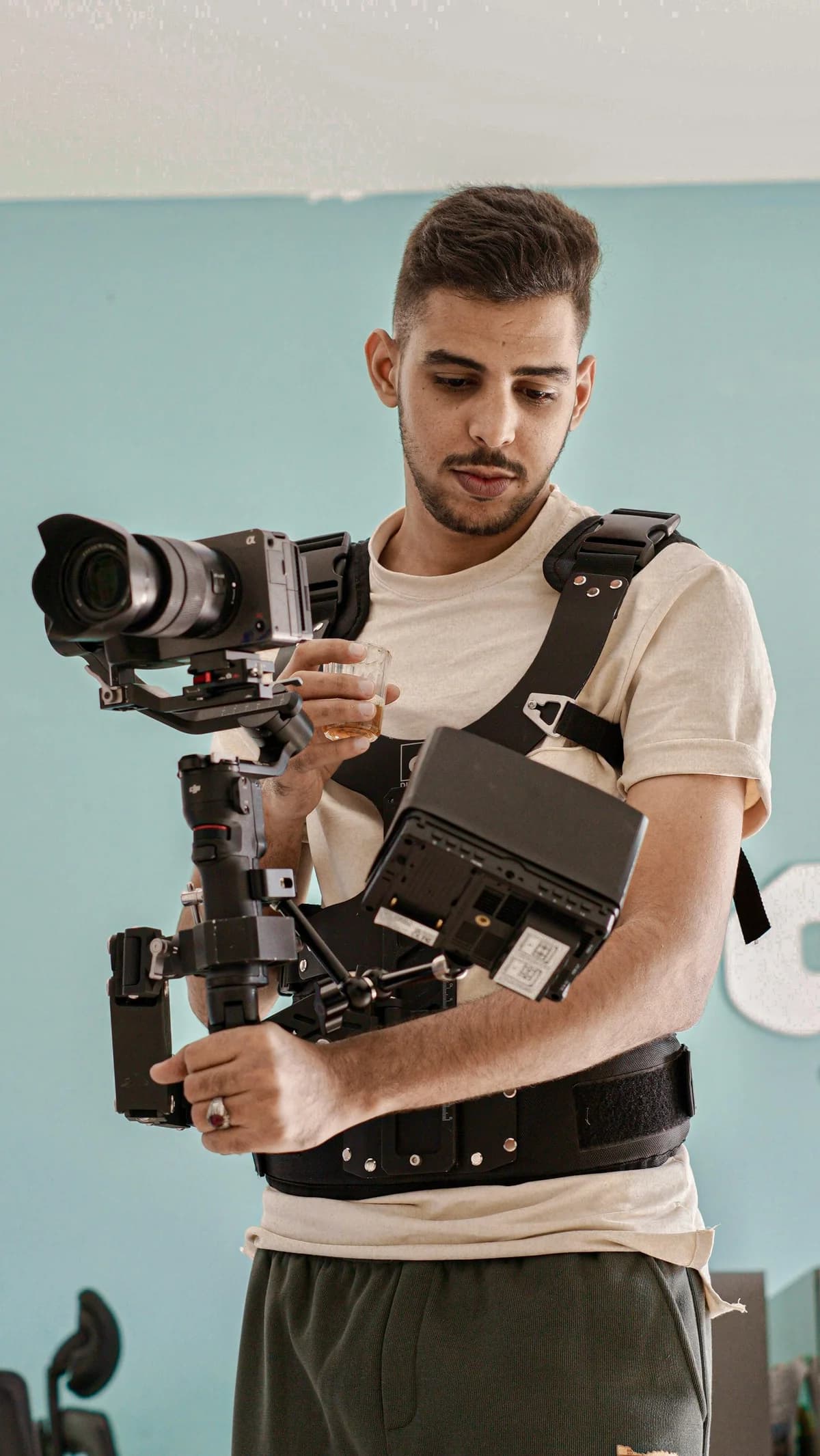 A camera operator with a gimbal-mounted camera and a field monitor at a live production