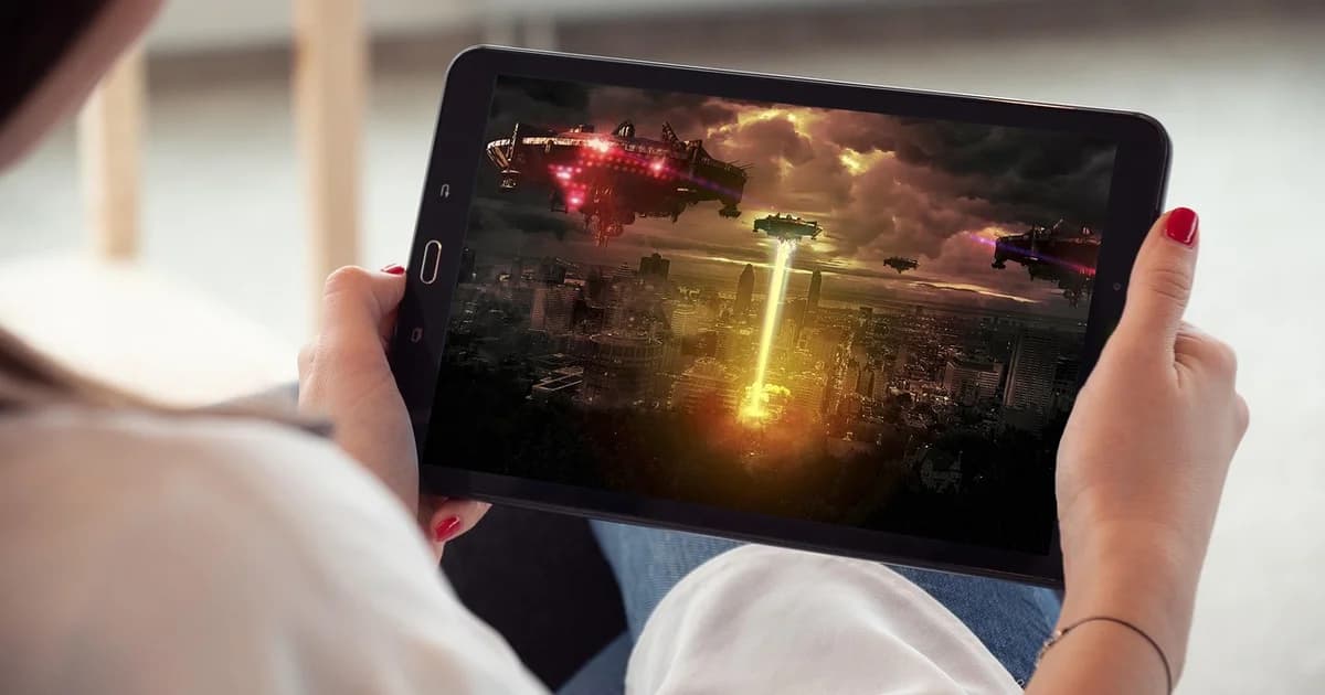 Un spectateur tenant une tablette et regardant un film à la demande